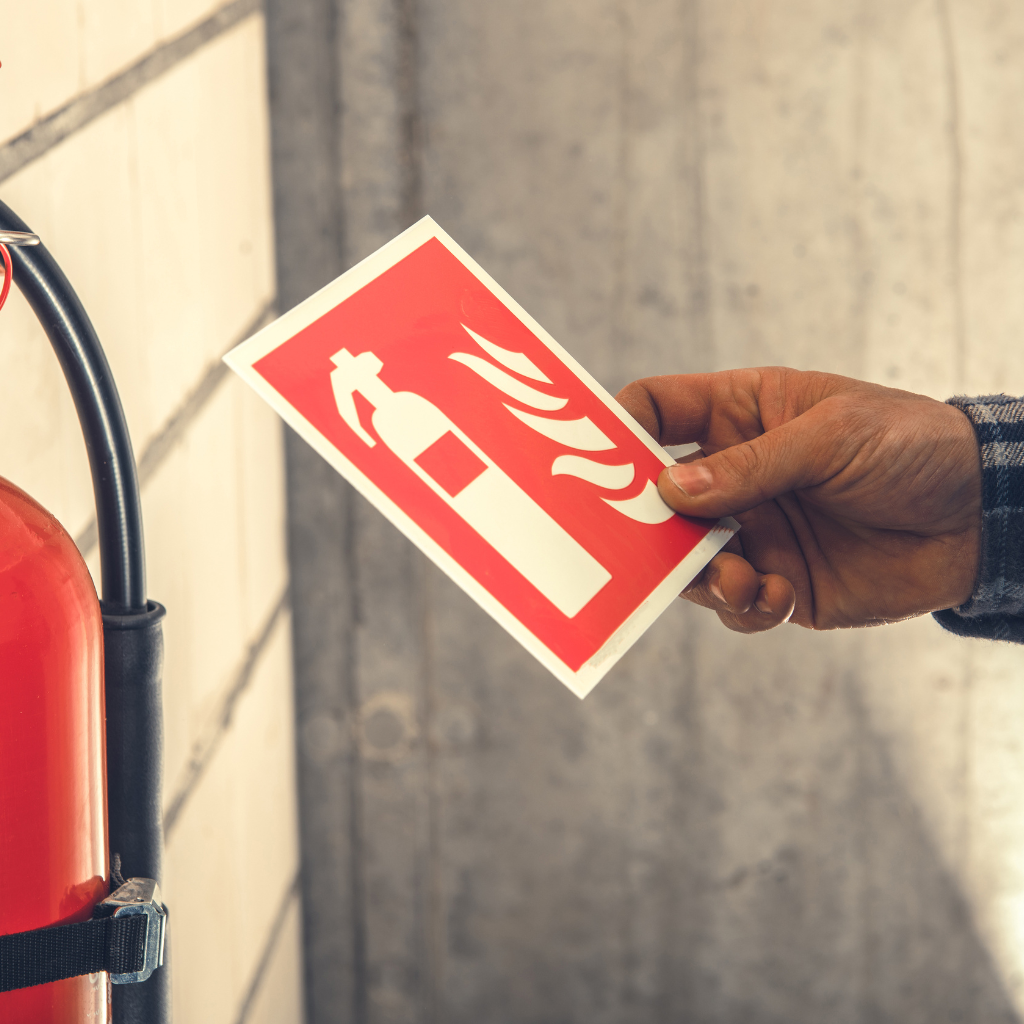 A Fire extinguisher sign being picked up