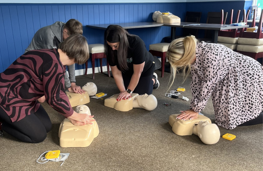 Employees learning CPR on a first aid training course