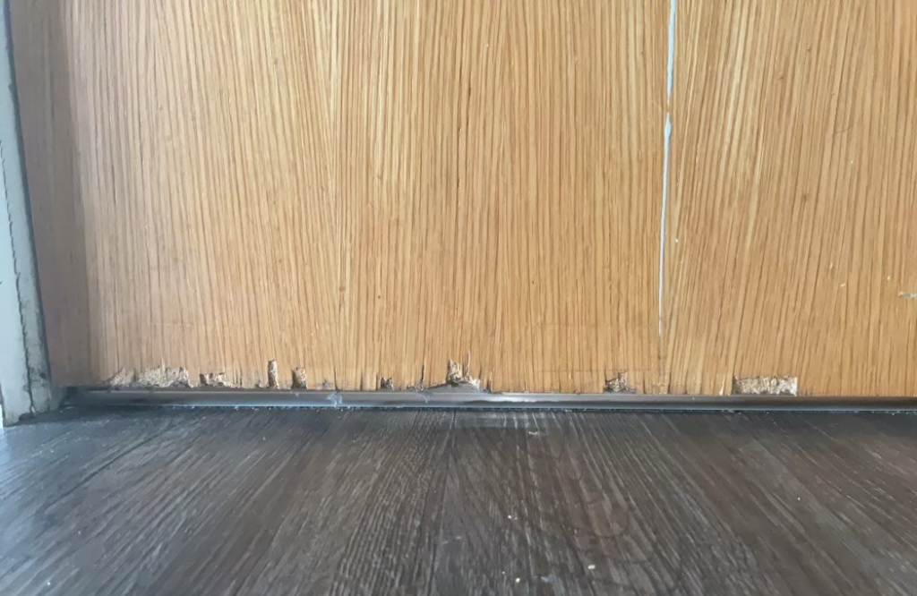 The bottom of a damaged fire door