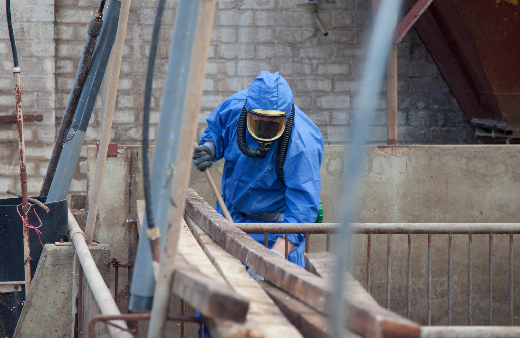 An asbestos surveyor onsite in full PPE